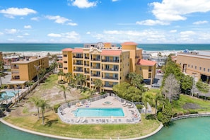 A hotel with a pool, multiple balconies, and a view of the beach. - Ocean View Oasis on the Gulf! (Treasure Island)
