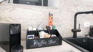 A kitchen with a coffee bar, a Krups coffee maker, and a microwave. - Lulu Suite in the center (Cagliari)