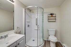 A modern bathroom with a glass-enclosed shower, a white sink, and a toilet. - Fish, Bike & Hike! Wooded Irons Getaway Near River (Irons)