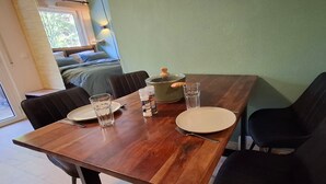 Uma mesa de jantar com cadeiras, pratos, copos e temperos.