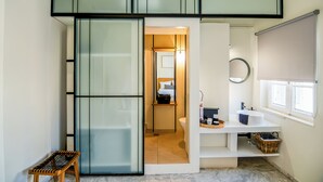 Une petite salle de bain comprenant des toilettes, un lavabo et des étagères de rangement.