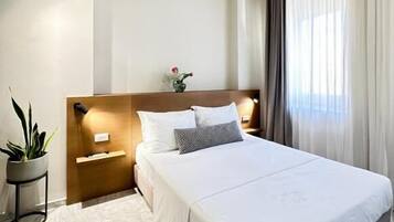 Suite Deluxe, vistas a la ciudad | Caja fuerte, tabla de planchar con plancha, wifi gratis