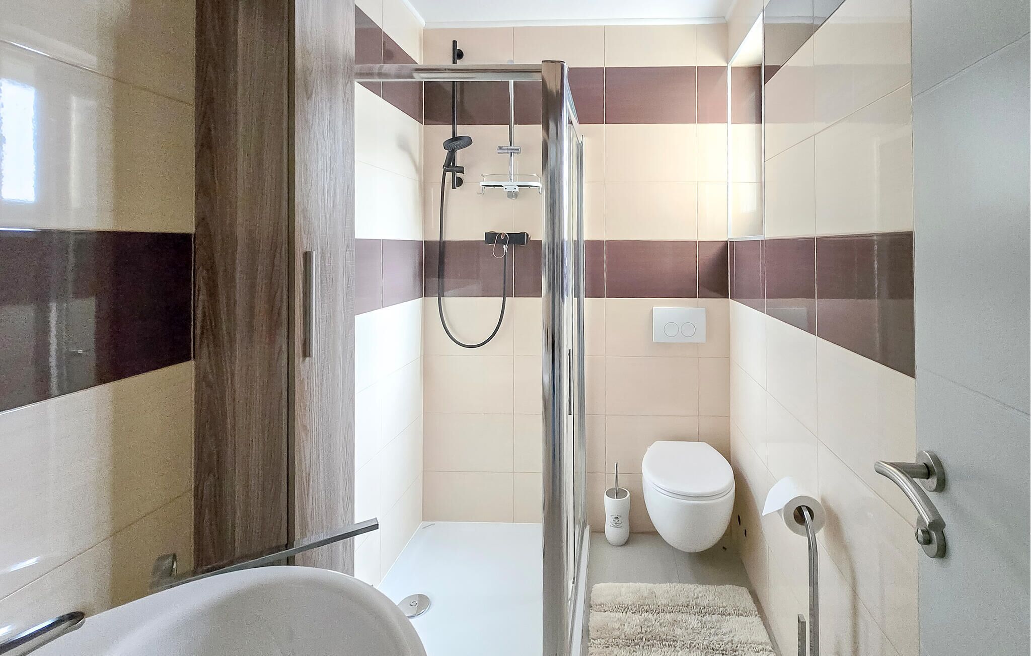 Un baño moderno con cabina de ducha de vidrio, inodoro y bañera.