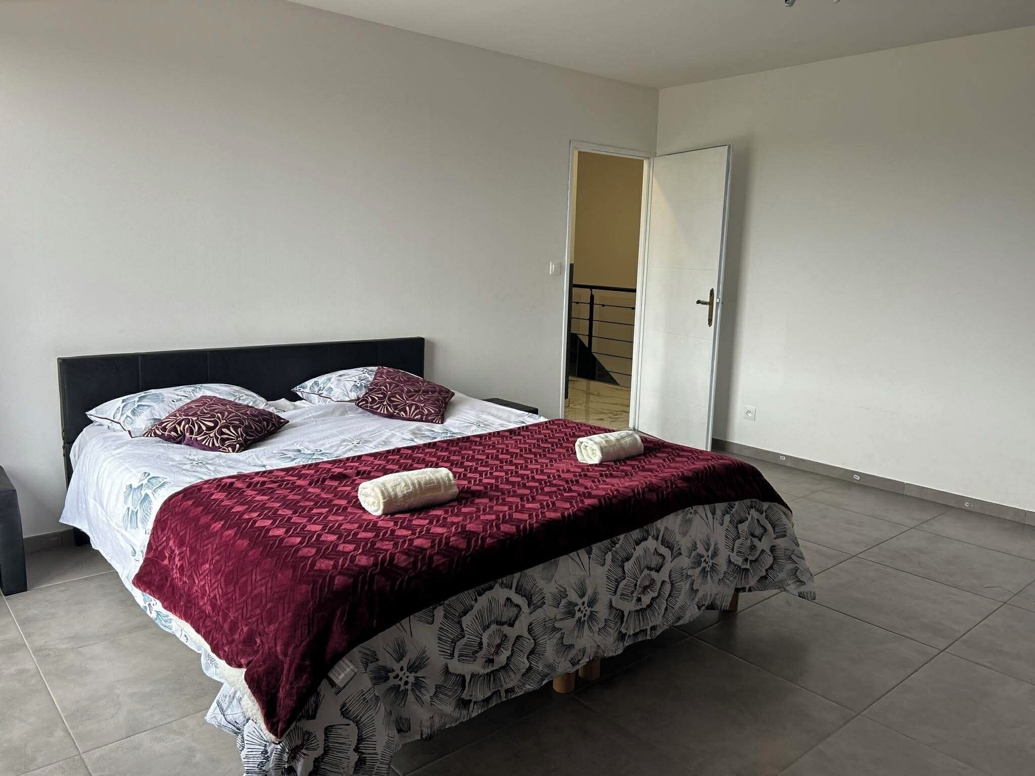 A bedroom with a bed, pillows, and a blanket.