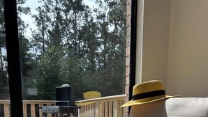 Aurinkoinen huone, josta on näkymä uima-altaalle ja ulkotilaan, jossa on istuimia.