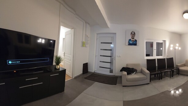 A modern apartment with a living room, dining area, kitchen, and a TV. - Poolside cottage (Oinville-sur-Montcient)