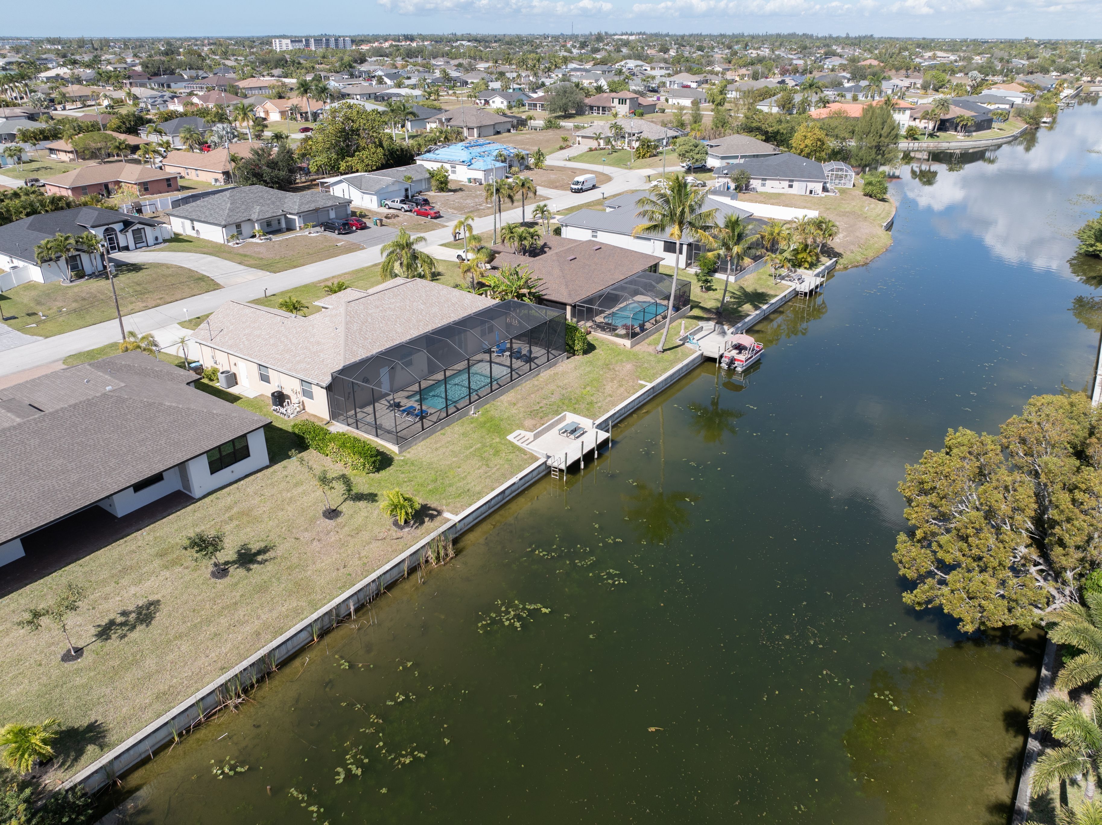 A residential area with houses, a swimming pool, and a canal.