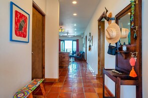 A hallway with a tiled floor, wooden doors, and a bench. - Ocean View Condo w/ Rooftop Terrace & Pool (La Paz)