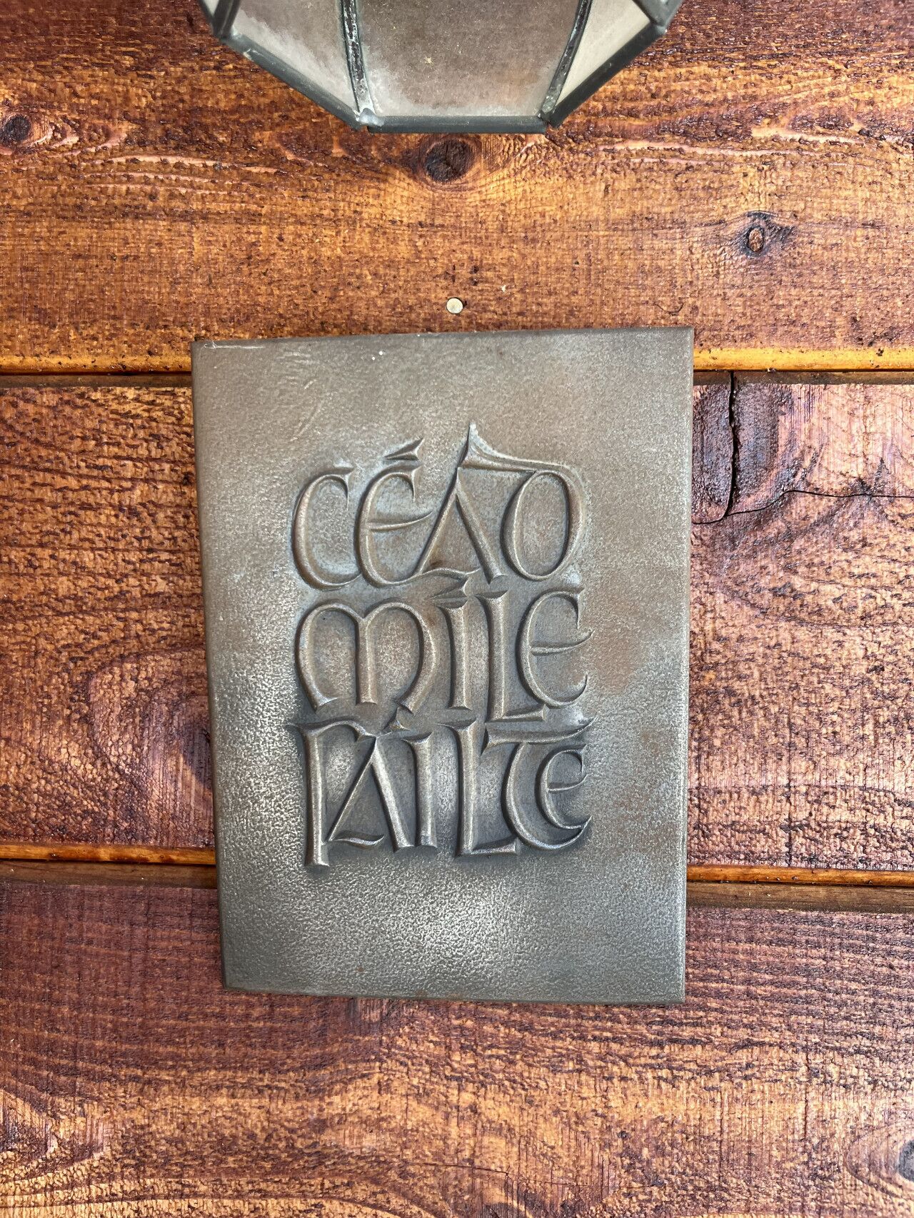 Una placa metálica con texto en relieve sobre una superficie de madera.