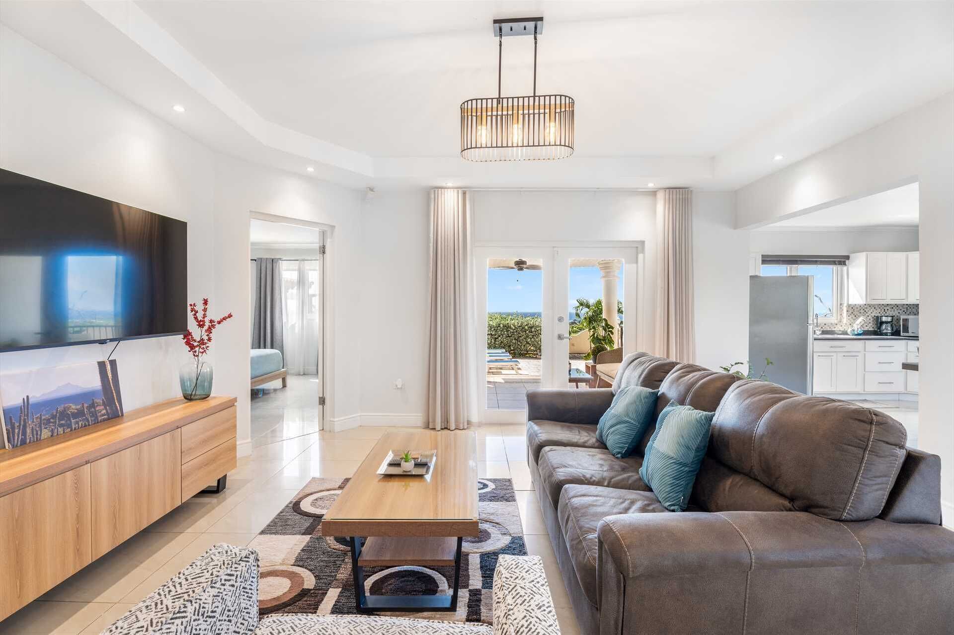 A modern living room with a leather sofa, wooden coffee table, and a flat-screen TV.