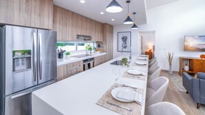 A modern kitchen with a large island, stainless steel appliances, and pendant lighting. - Luxury Walk-to-Beach 3BR Oasis , Playa Avellanas (Playa Avellanas)