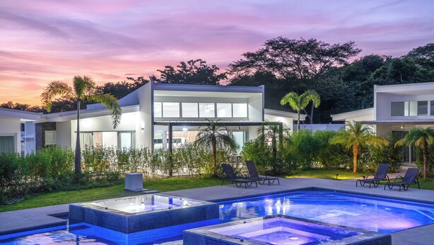A modern house with a swimming pool, two lounge chairs, and a well-maintained garden. - Luxury Walk-to-Beach 3BR Oasis , Playa Avellanas (Playa Avellanas)