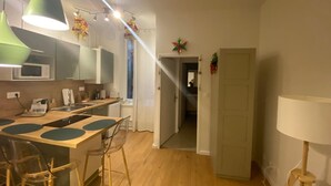 Une cuisine moderne dotée d’un îlot central, de tabourets de bar et de luminaires suspendus.