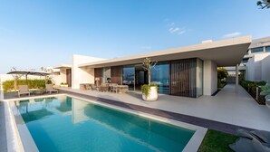 A modern house with a swimming pool, outdoor furniture, and a patio area. - 4BR Coastal Haven w Private Pool Al Zorah (Ajman)