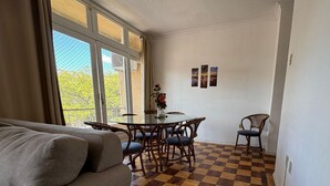A living room with a checkered floor, a round glass table, and a sofa.