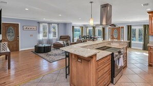 A spacious kitchen with a large island, wooden cabinets, and a modern stove. - Pond View Retreat | Bright & Spacious 3BR (West Columbia)