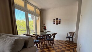 Un salon avec un sol à carreaux, une table ronde en verre et un canapé.
