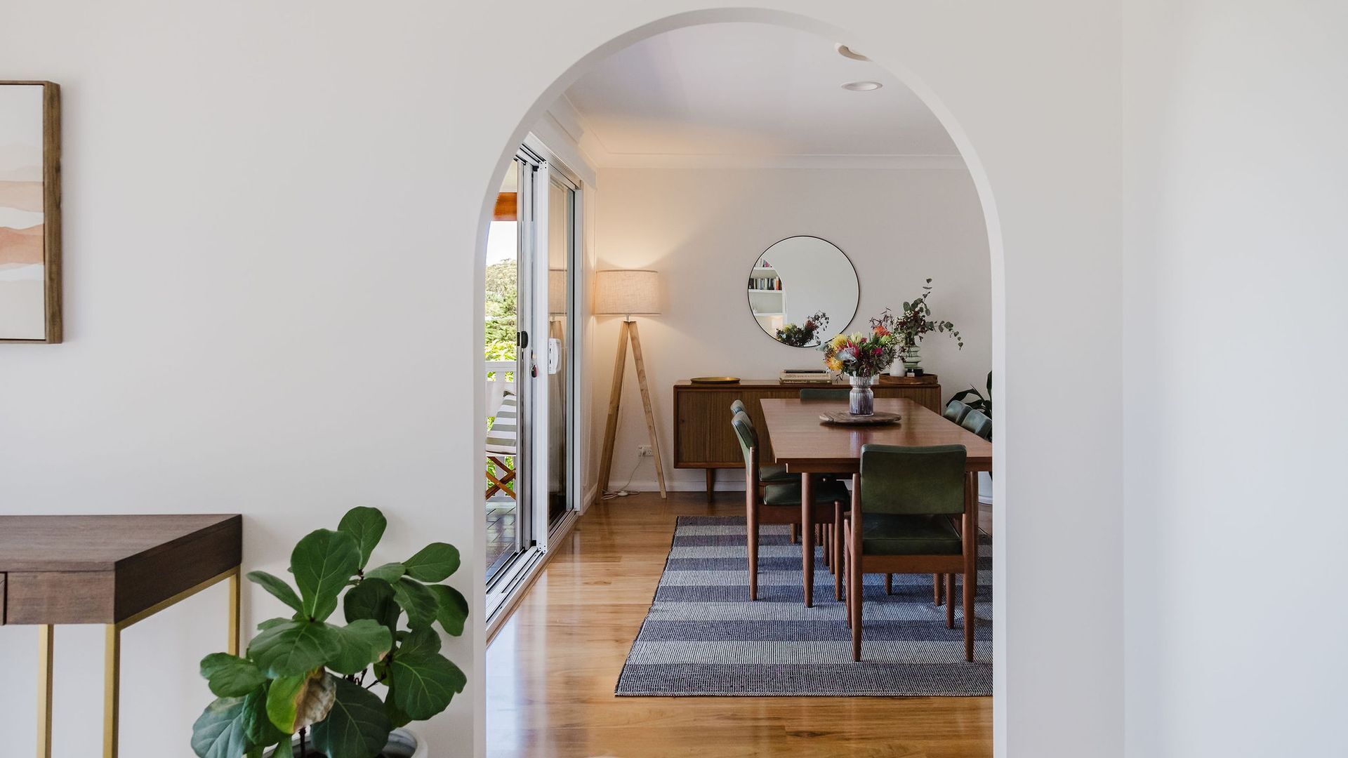 Un comedor moderno con una mesa de madera, sillas y un tapete.