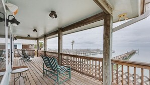 A wooden deck with a view of a pier and beach. - GetawaY at Mi Casita (Rockport)