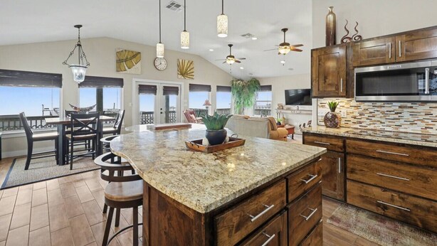 A spacious kitchen with a large island, wooden cabinets, and modern appliances. - GetawaY at Mi Casita (Rockport)