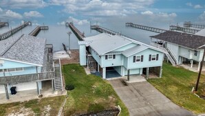 A coastal residential area with houses connected by walkways to piers extending into the water. - GetawaY at Mi Casita (Rockport)