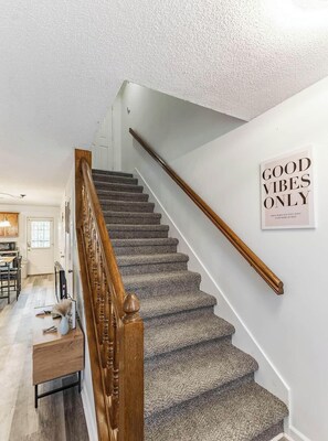 A staircase with a wooden handrail and carpeted steps leading to a landing. - Cozy Cottage 4 Beds home Near Central Decatur (Decatur)
