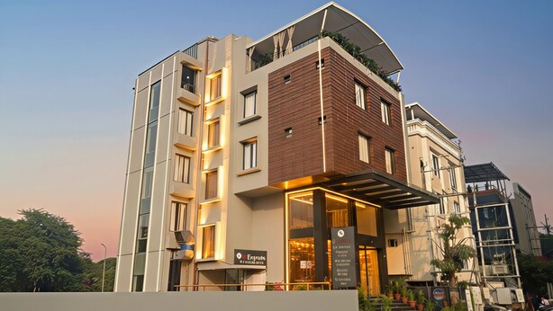 A modern hotel with a brick facade, large windows, and a covered entrance area. - M Square Express (Indore)