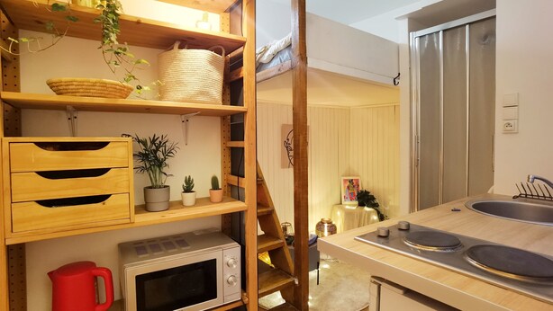 A compact kitchen with wooden shelves, a microwave, a red kettle, and a stainless steel refrigerator. - Cozy Mini-Studio for 2 Near Louvre/ Metro/Elevator (Paris)