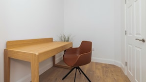 A corner room with a wooden desk and a brown chair. - Dean Swift Square (Dublin)