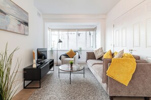 En moderne stue med sofa, sofabord og tv-møbel.