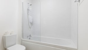 A bathroom with a glass-enclosed shower, a white toilet, and a bathtub. - Dean Swift Square (Dublin)
