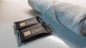 Een handdoek en twee verzorgingspakketten voor in een hotel op een tafel.
