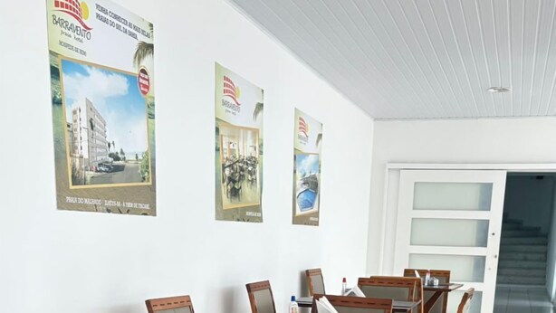 Een vergaderruimte met houten tafels en stoelen, een betegelde vloer en posters aan de muren.