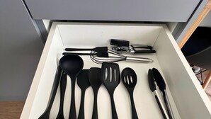 A drawer containing various kitchen utensils including spatulas, tongs, and a whisk. - Hype Vila Mariana (São Paulo)