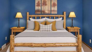 Un dormitorio con cabecera de cama de madera, dos mesitas de noche con lámparas, y una pared azul con un cuadro.