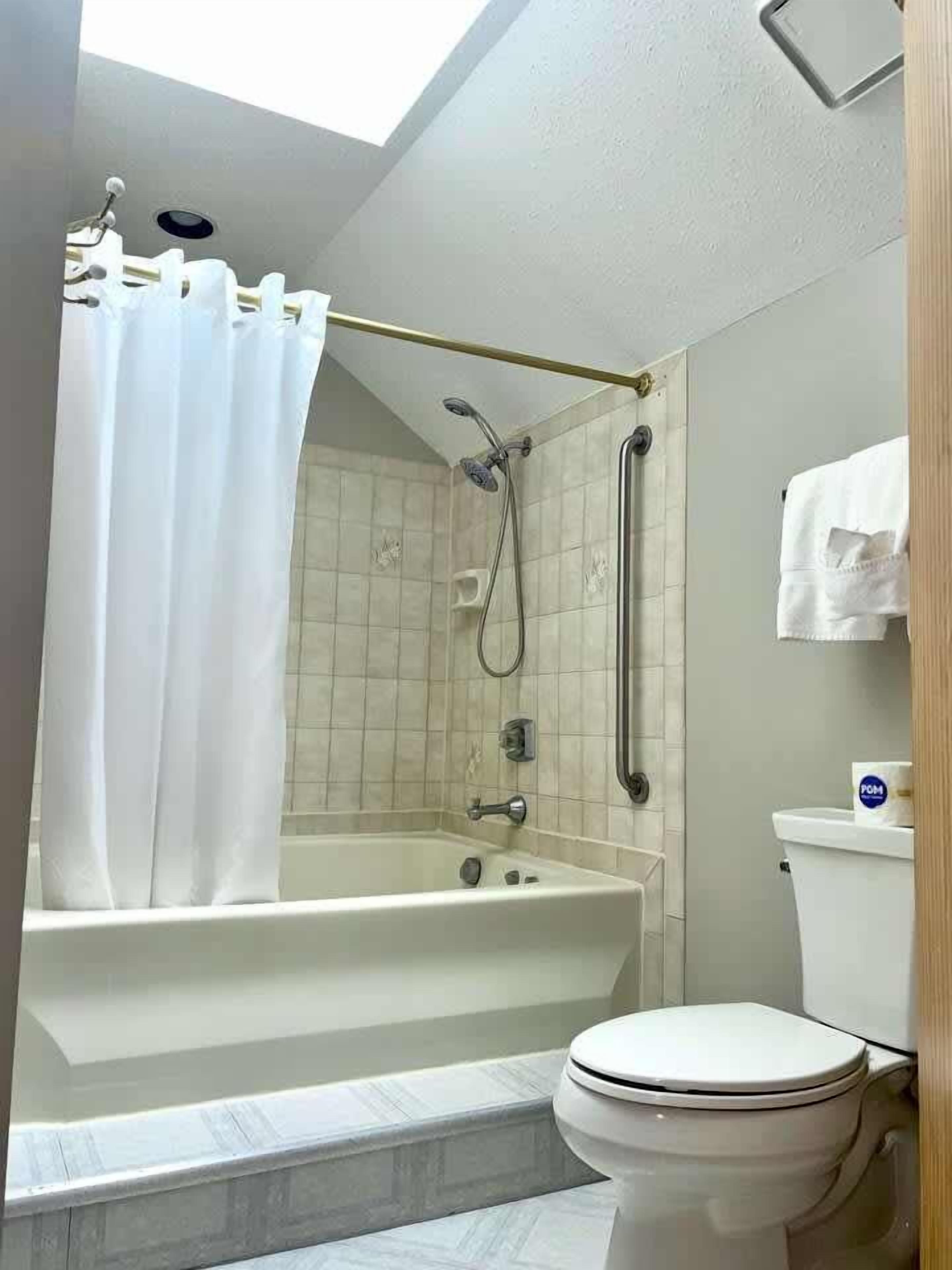 A bathroom with a bathtub, toilet, and shower.