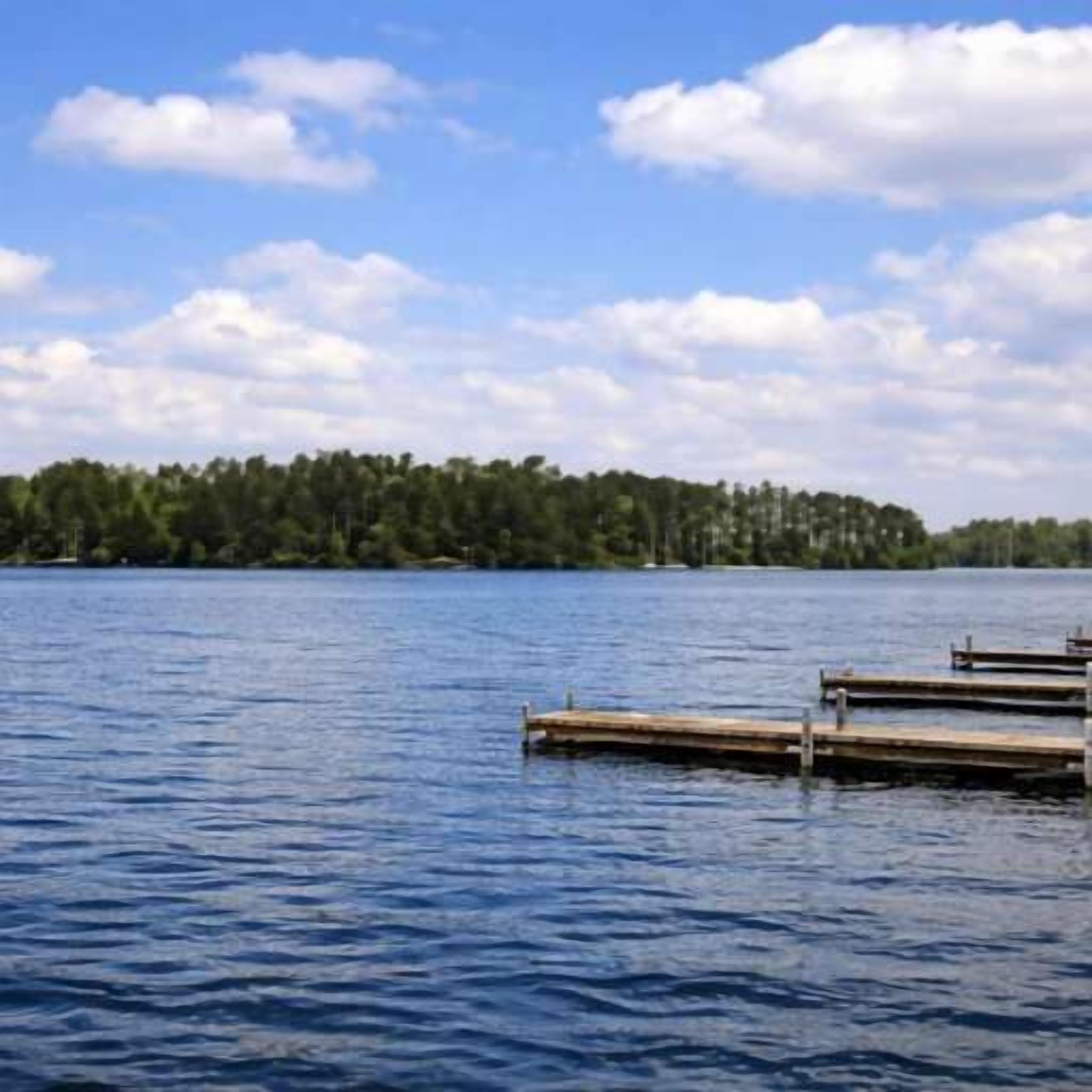 Un lago tranquilo con muelles de madera que se adentran en el agua.