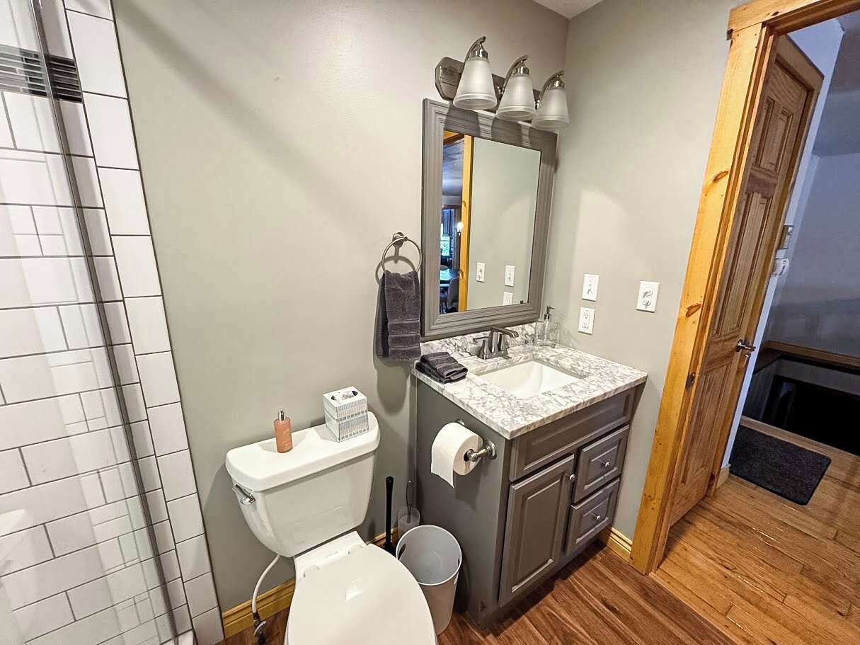 Ein Badezimmer mit Toilette, Waschbecken, Spiegel und Dusche.