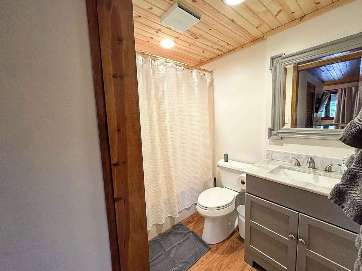 Une petite salle de bain comprenant des toilettes, un lavabo et un miroir.