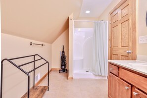 Un bagno con doccia, un armadietto in legno e una ringhiera in metallo.