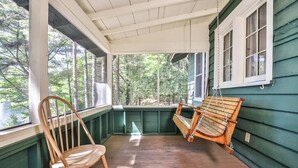 Eine Veranda mit einem Holzstuhl und einer Hängematte.