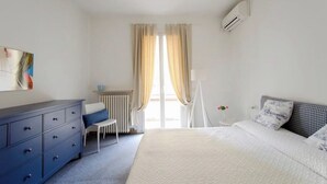 Ein Schlafzimmer mit Bett, Kommode, Stuhl und Heizkörper.