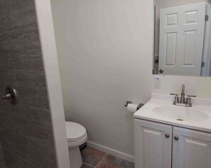 Ein Badezimmer mit Toilette, Waschbecken und Spiegel.
