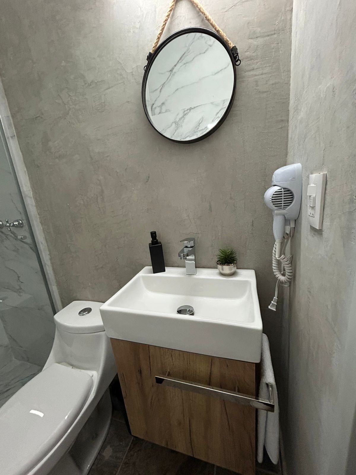 Ein Badezimmer mit Toilette, Waschbecken und Dusche.