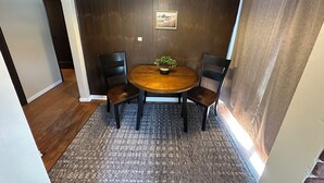 A dining area with a round table, two chairs, a potted plant, and a hanging light fixture. - Super Clean 2BR House: Quiet, Safe, Near Hwy, Big TV, Nightlife, Porch, by River (Beaver)