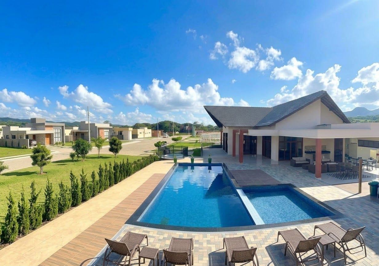 A modern hotel with a swimming pool, outdoor seating, and a view of the surrounding landscape.