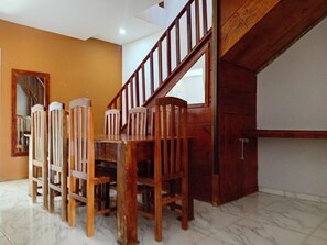 A dining area with a wooden table and chairs, a staircase, and a tiled floor. - House with 6 bedrooms, 4 suites, 2km from the center.  (Bananeiras)