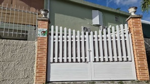 A gated property with a white picket fence, brick pillars, and a garage door.
