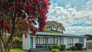 Un bâtiment moderne de plain-pied, doté d’un toit plat, de grandes fenêtres et d’un petit porche à l’avant.