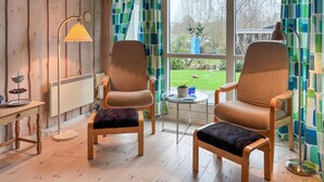 Une pièce chaleureuse avec deux fauteuils, une petite table et un lampadaire.